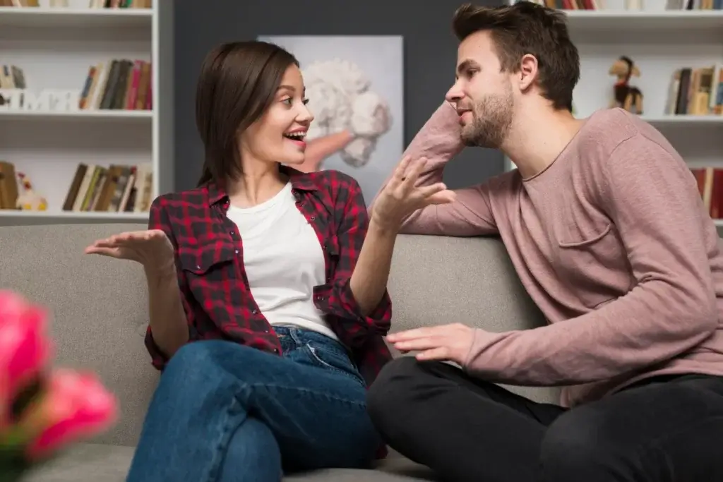Man and woman seated on a couch, sharing an empathetic conversation.